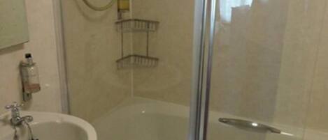 A bathroom with a sink, a glass shower enclosure, and a bathtub.