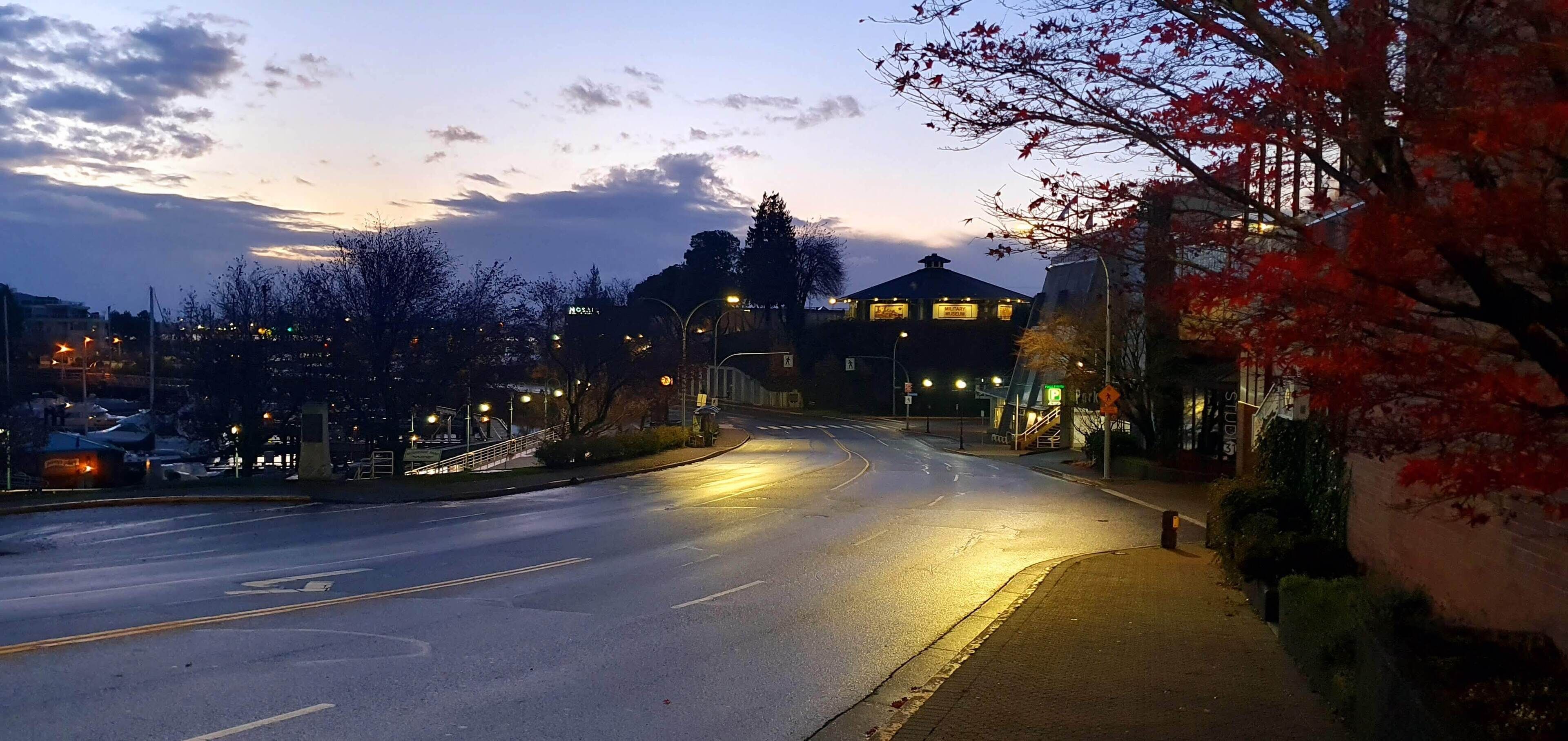 A street view at dusk with a building featuring a sign that reads "Mansion."