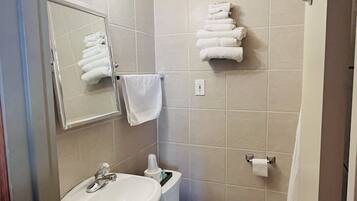 Un baño con lavamanos, inodoro y perchero para toallas.