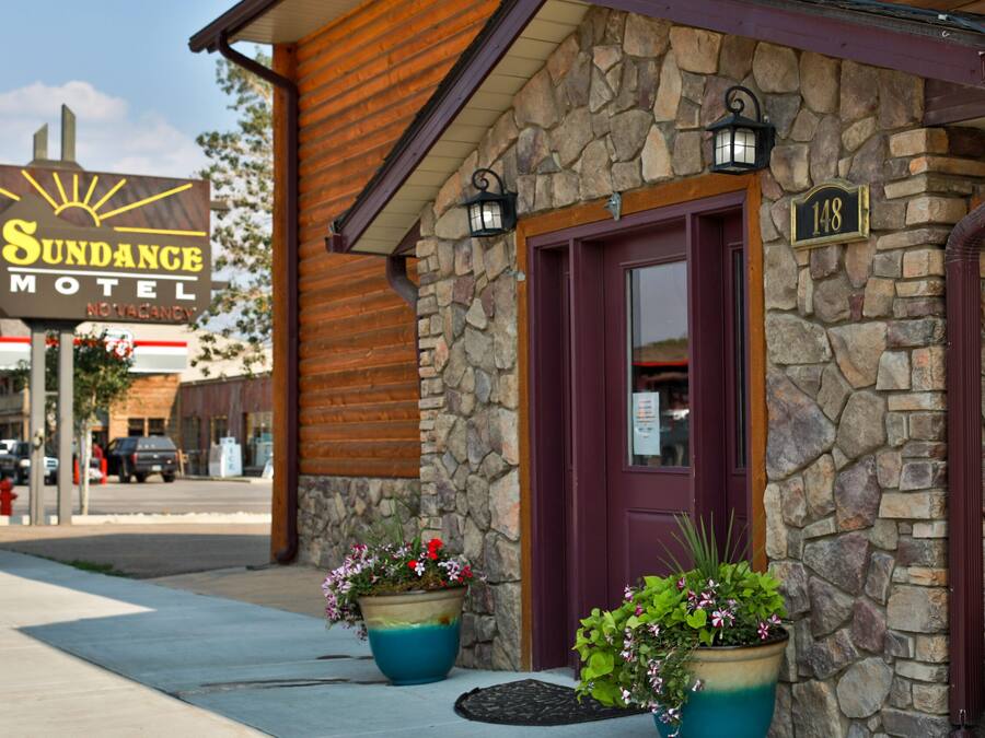 A motel with a stone facade, a wooden exterior, and a sign indicating it is the Sundance Motel.