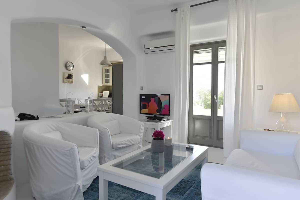 Suite, al piano terra | Area soggiorno | TV a schermo piatto