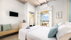 Ein Schlafzimmer mit Bett, Fernseher, Kleiderschrank und einem Fenster mit Blick.