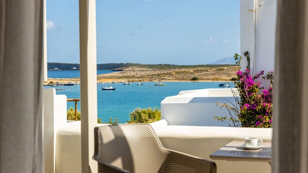 Ein Balkon mit Blick auf das Meer, Boote und ein entfernter Berg.