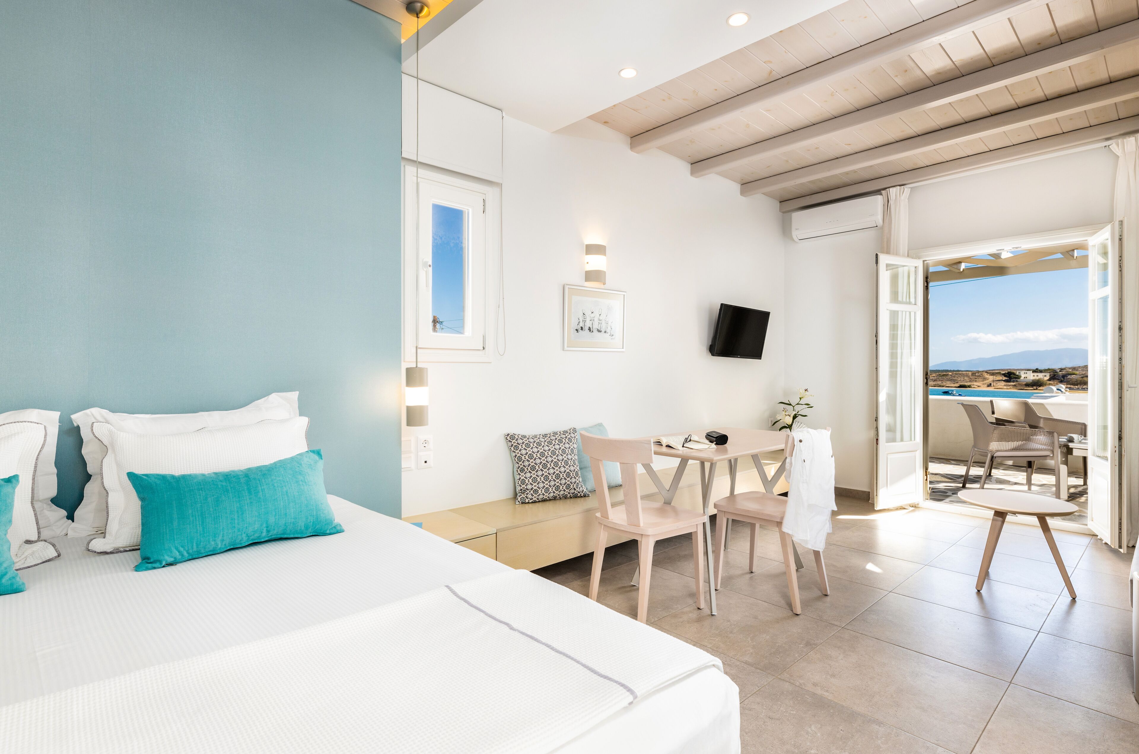 Een hotelkamer met een bed, een bureau en uitzicht.