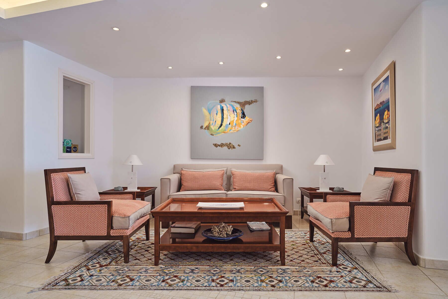 Een woonkamer met een bank, twee fauteuils, een salontafel en een vloerkleed met dessin.