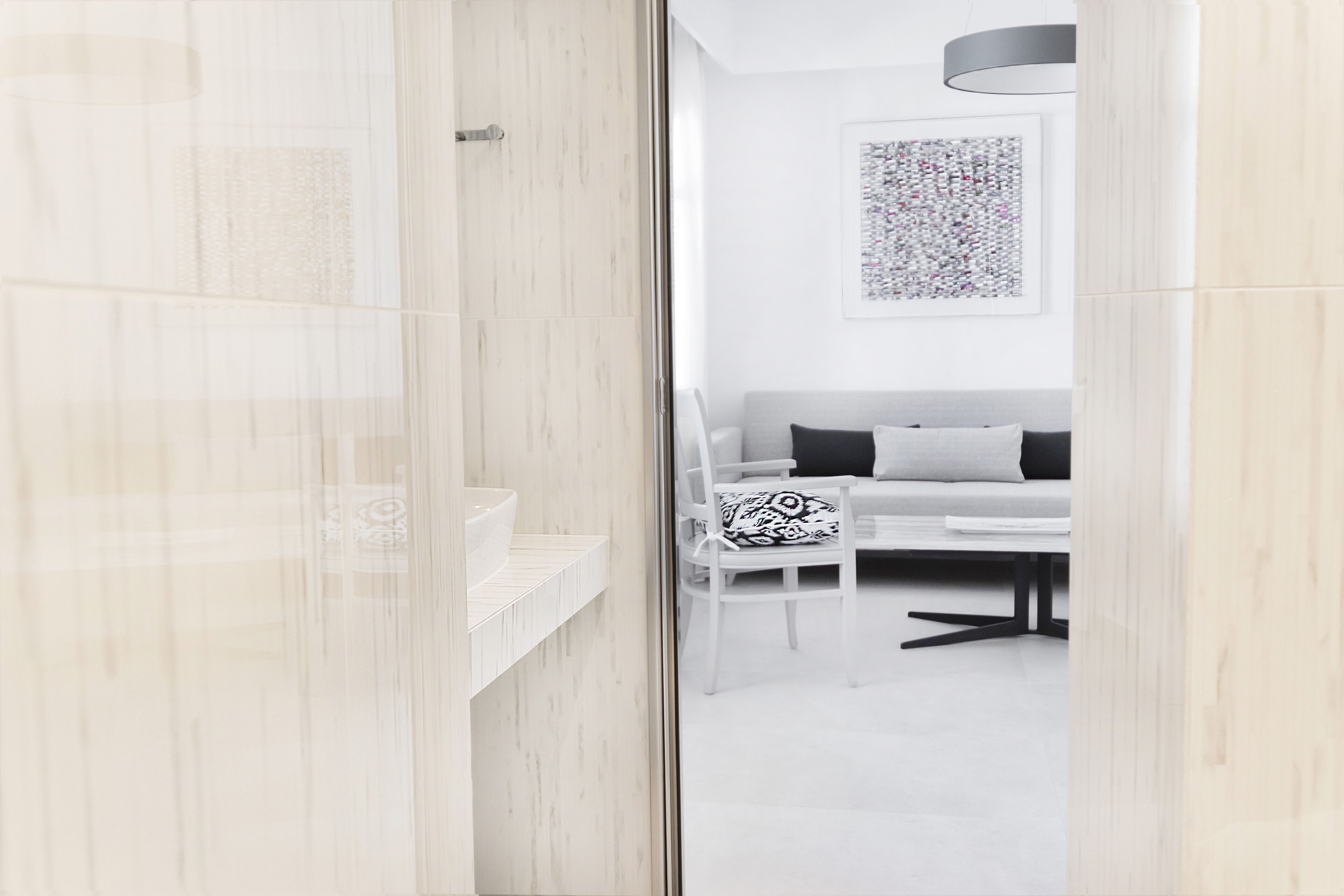A modern bathroom with a glass shower enclosure and a white sink.