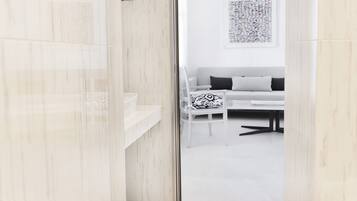 A modern bathroom with a glass shower enclosure and a white sink.