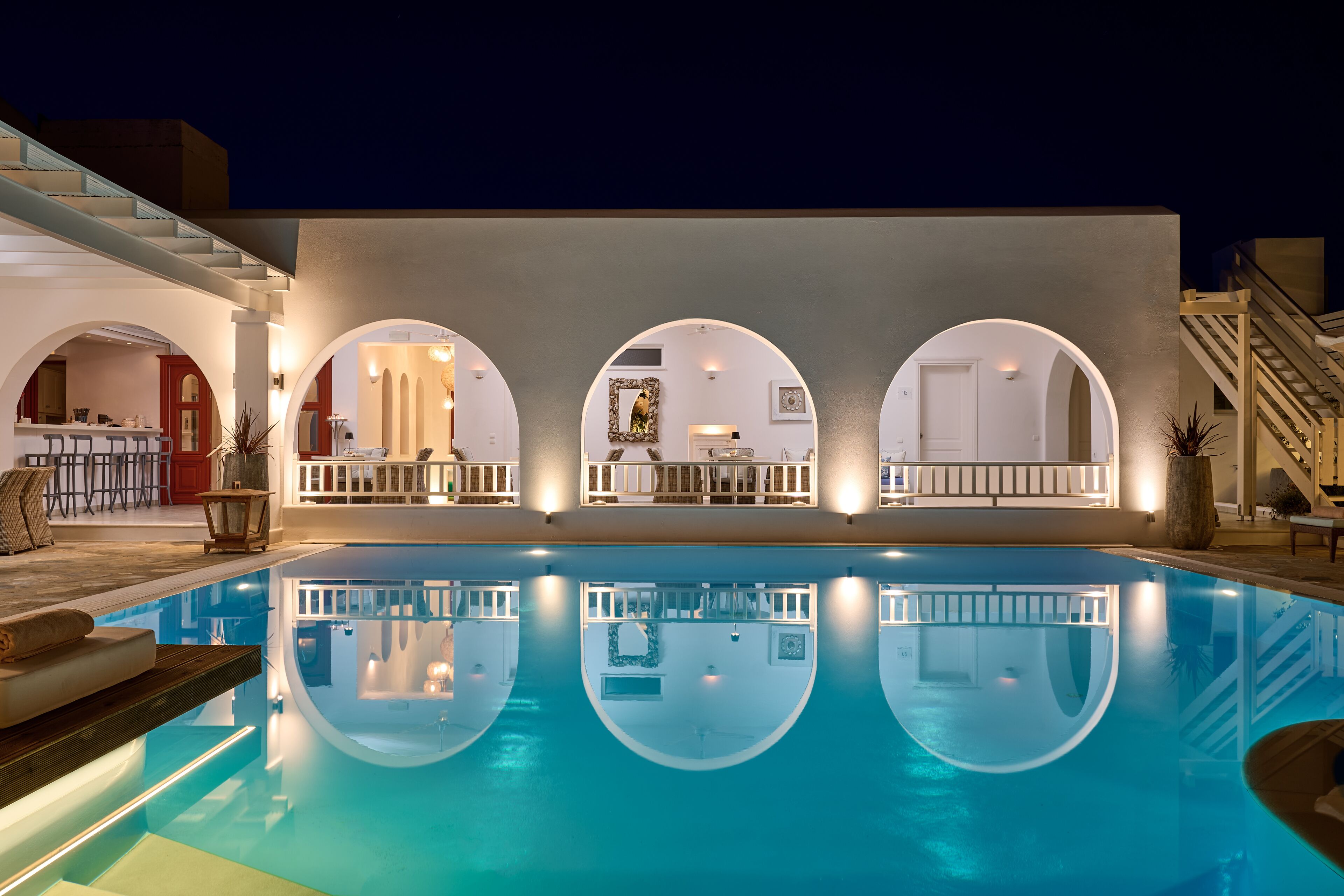 A swimming pool with a reflection of the adjacent building's interior.