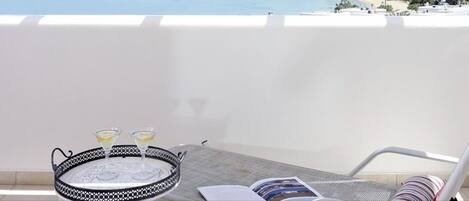 Een balkon met een tafel, twee martini glazen en een dienblad.