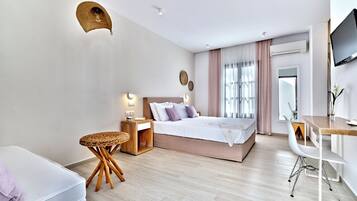 Una camera da letto moderna con un letto, un comodino, una sedia, una scrivania e una televisione.