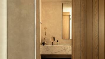 A modern bathroom with a marble sink, wooden paneling, and a mirror.