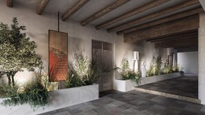 Un intérieur moderne avec des poutres en bois apparentes, un sol carrelé en pierre et des jardinières intégrées, agrémentées de plantes vertes.