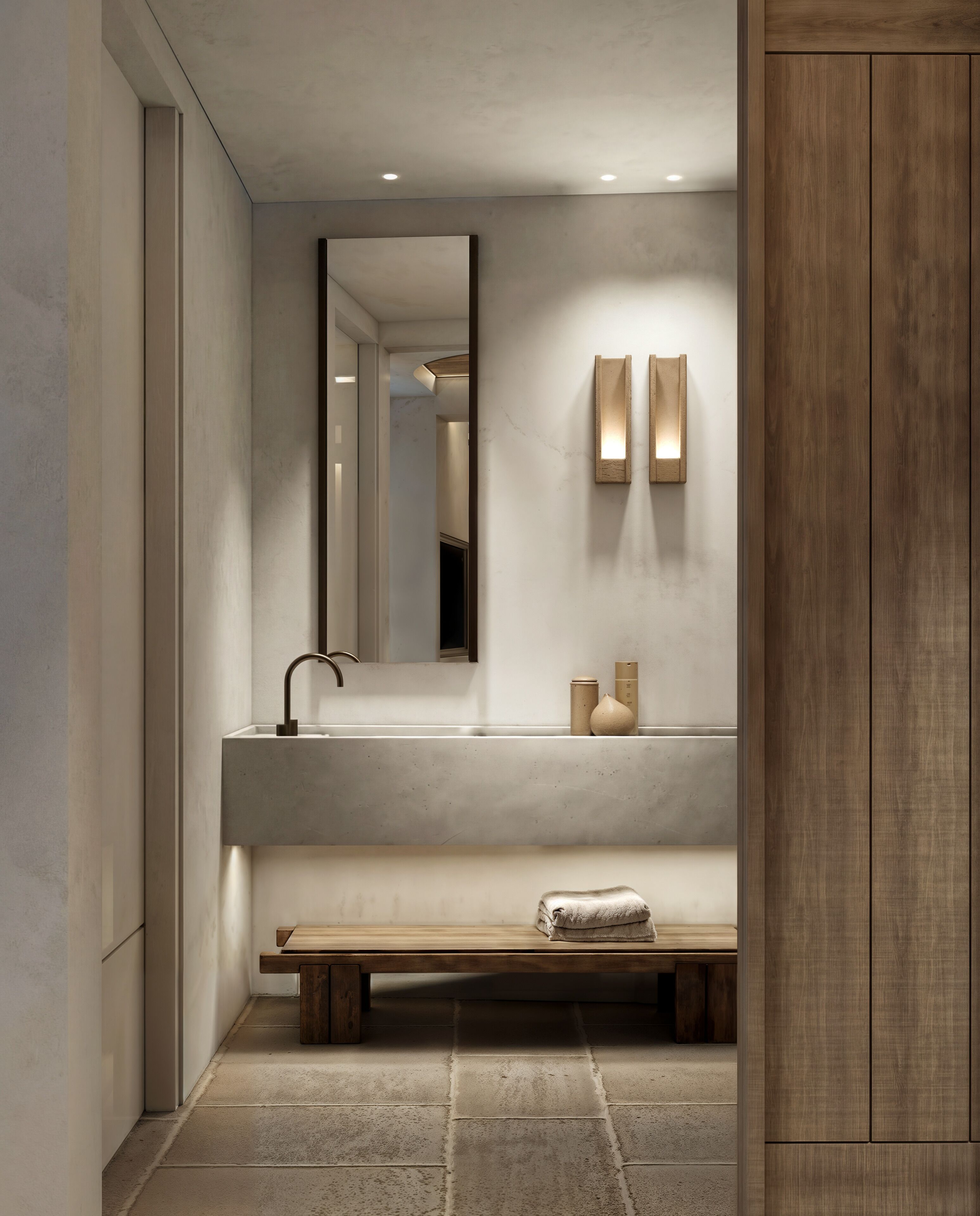 A modern bathroom with a large mirror, a sink, and a bench.