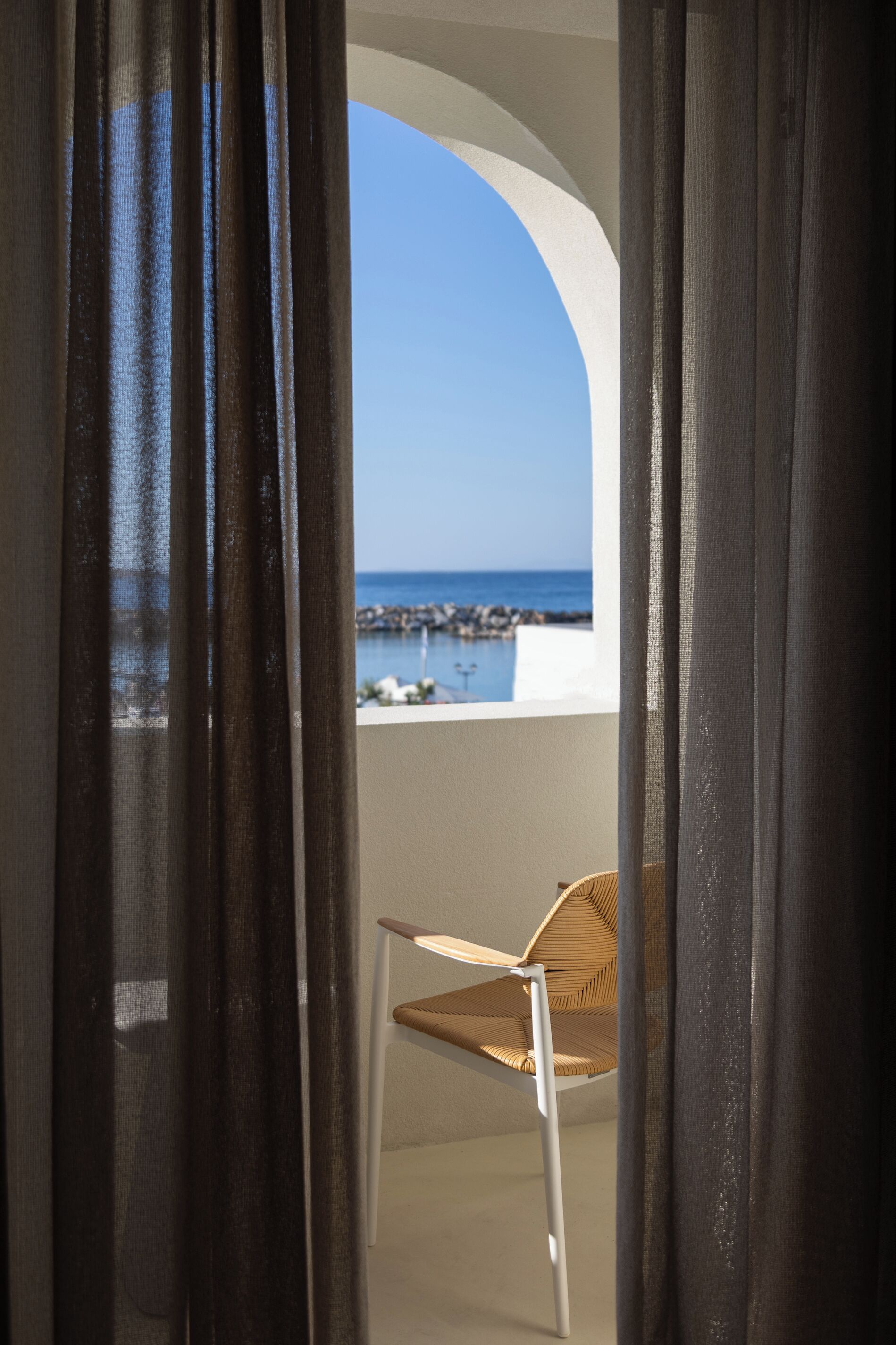 Un balcon avec vue sur la mer et une chaise.