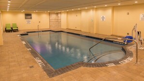 An indoor swimming pool with a no diving sign, a lifeguard chair, and a pool lift. - Holiday Inn Trophy Club by IHG (Roanoke)