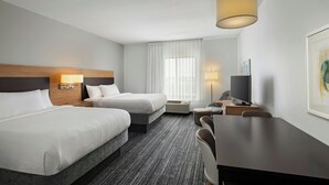 A hotel room with two beds, a desk, a chair, a TV, and a lamp. - TownePlace Suites by Marriott Ames (Ames)
