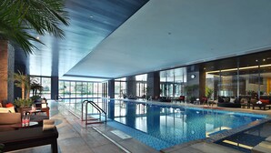 An indoor swimming pool with a modern design, including a lounge area with seating and a view of the outdoors. - Holiday Inn Chengdu High-Tech Center by IHG (Chengdu)