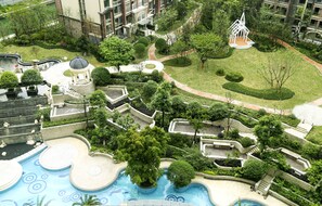 A landscaped garden with a swimming pool, a gazebo, and a small bridge.