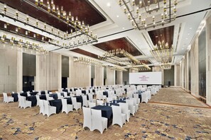 A large conference room with rows of tables and chairs, a stage with a screen, and multiple chandeliers. - Holiday Inn Chengdu High-Tech Center by IHG (Chengdu)