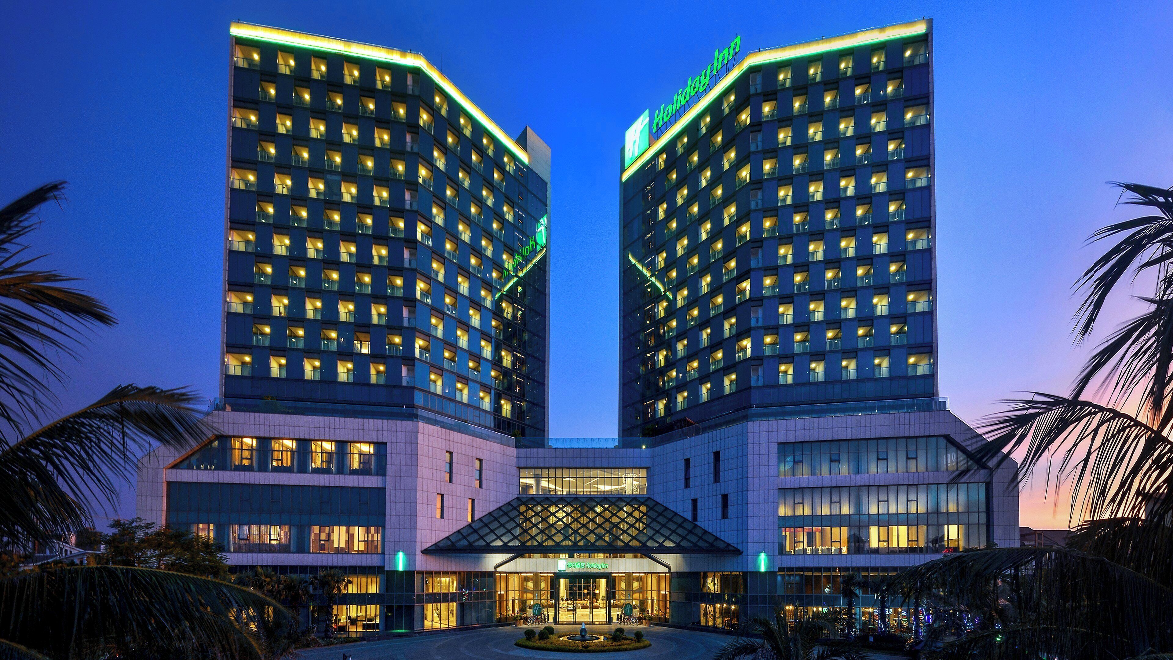 Un hotel con fachada simétrica, varios pisos y una entrada central.