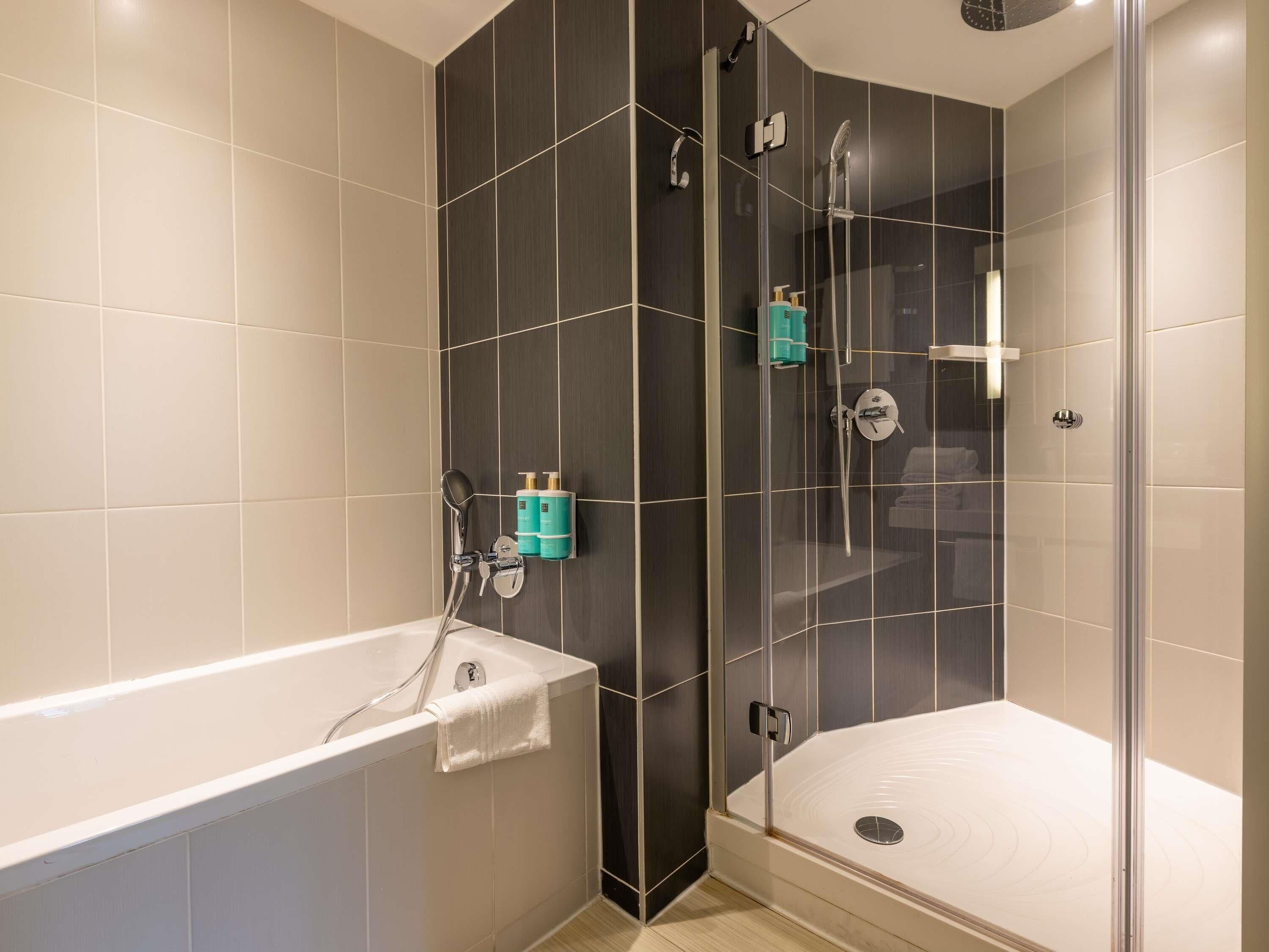 Un baño moderno con bañera, cabina de ducha con vidrio y un inodoro.