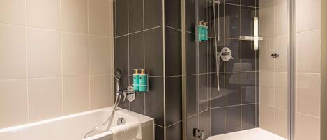 Un baño moderno con bañera, cabina de ducha con vidrio y un inodoro.