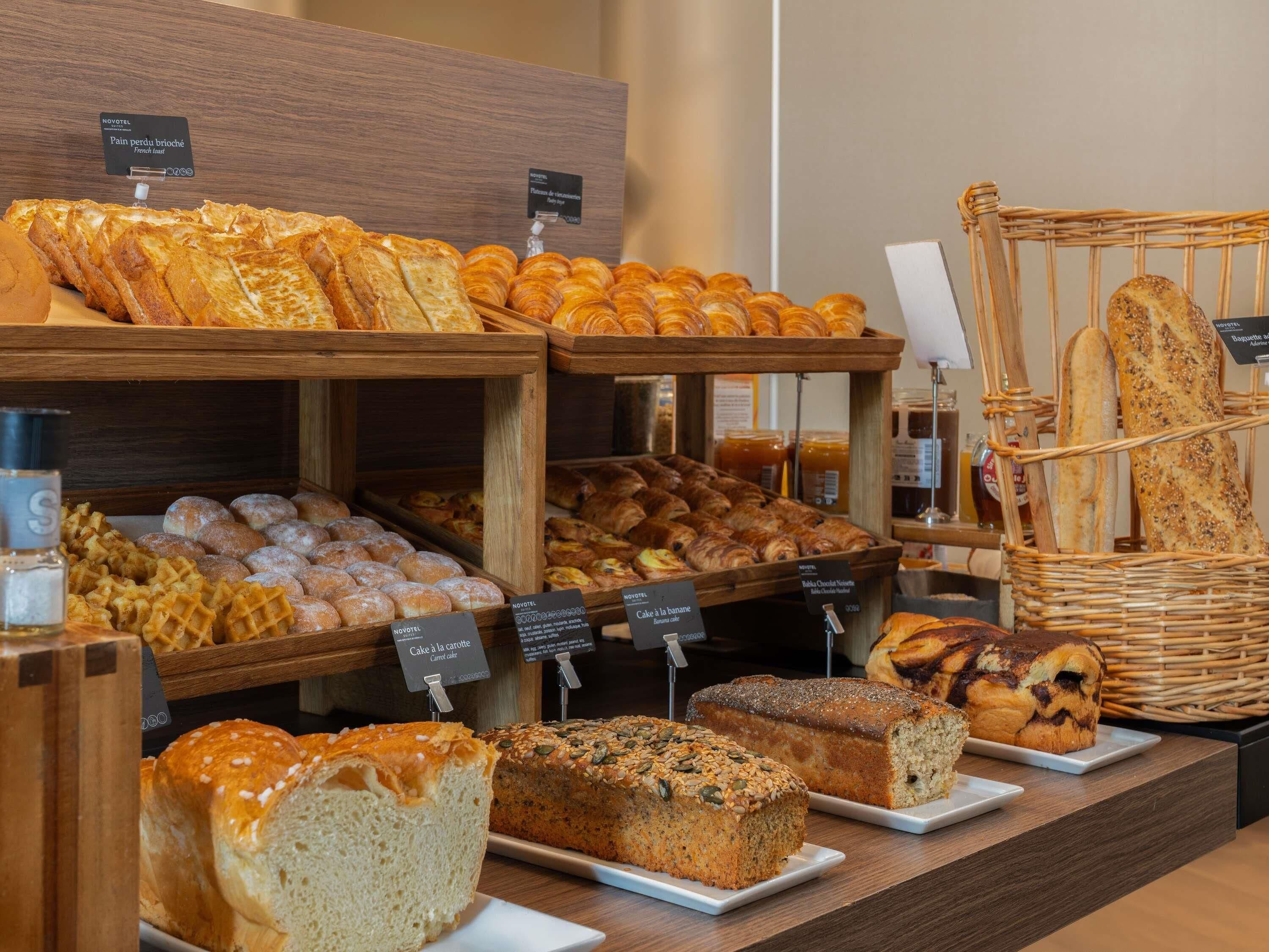 A bakery display with various breads, pastries, and cakes.