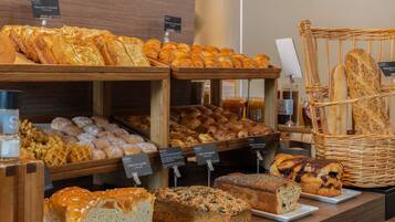 A bakery display with various breads, pastries, and cakes.