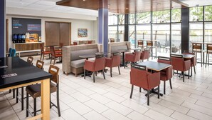 Un café moderne doté d’un bar à café, d’un espace salon et de grandes fenêtres.