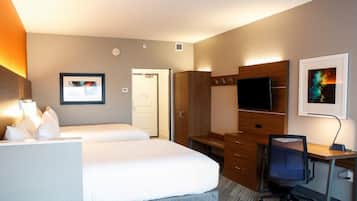 A hotel room with two beds, a desk with a chair, a television, and a wardrobe.