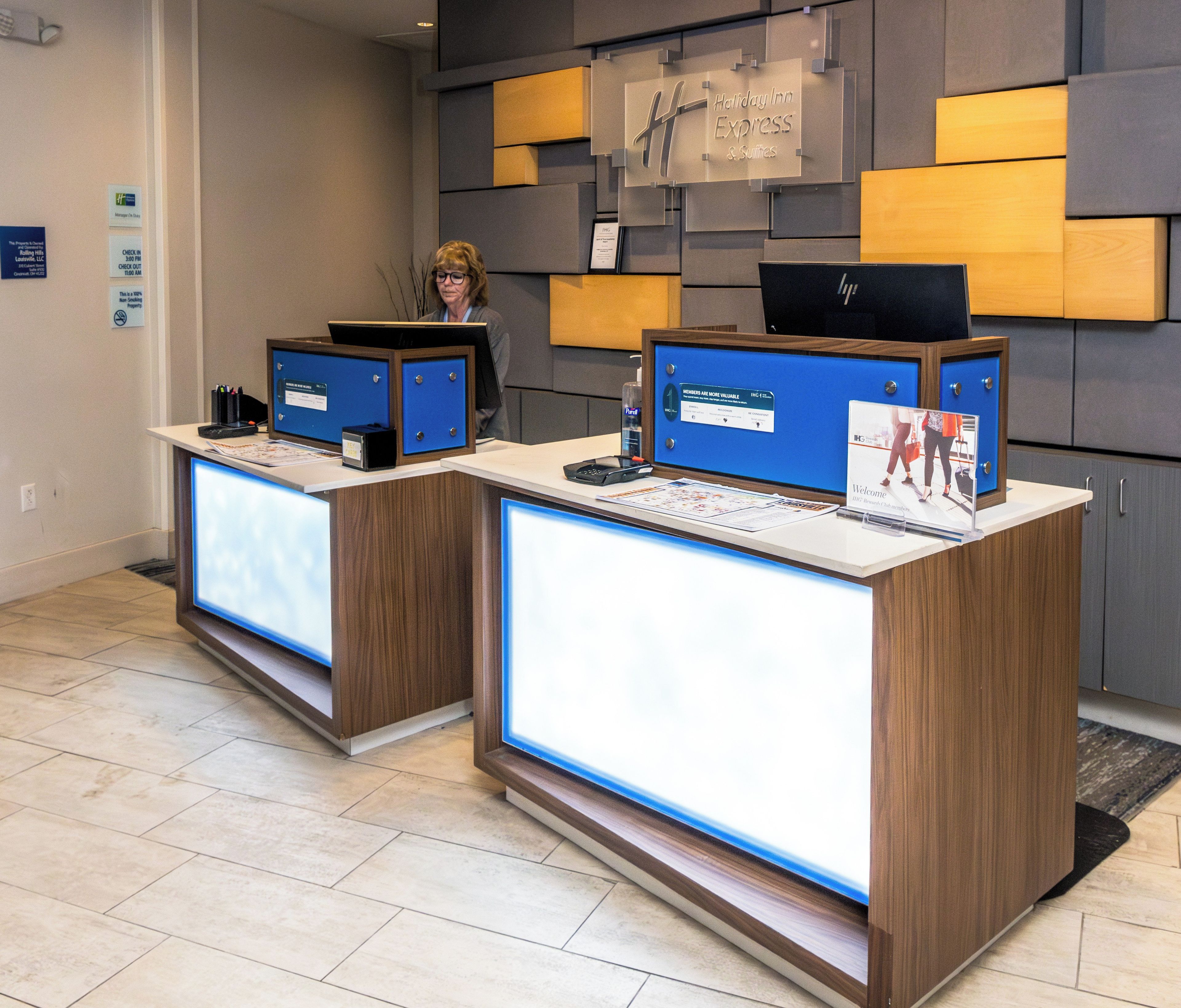 A reception desk with a computer, a framed welcome sign, and a check-in counter.