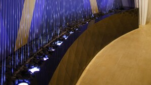 Ein modernes Interieur mit einer gewölbten Wand, die vertikale Linien und geometrische Muster zeigt.