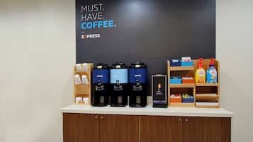 Um espaço com estação de café, diversos dispensadores, ponto de água quente e variedade de produtos de café expostos.