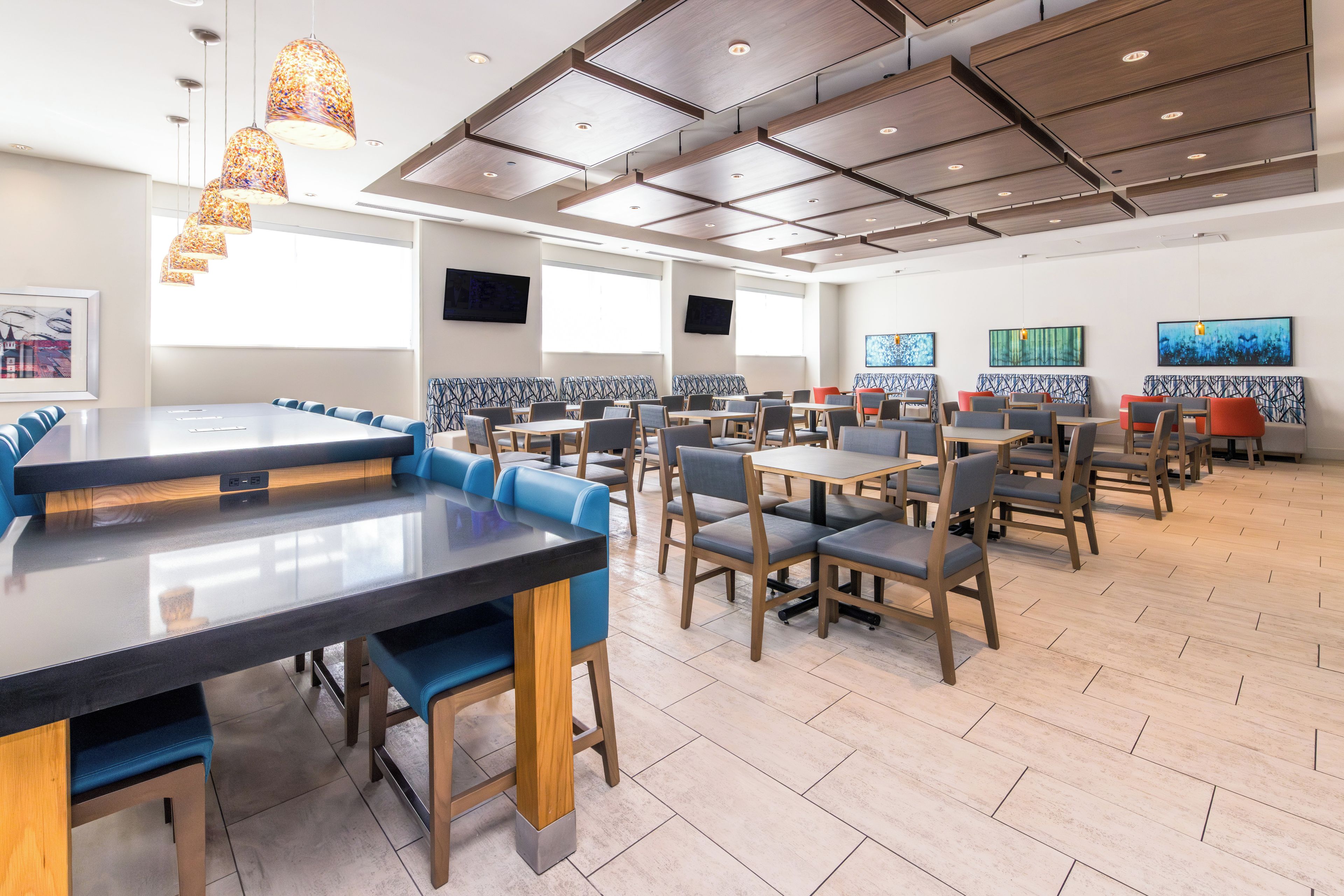 A modern dining area with high tables, booths, and a variety of seating options.