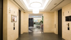 A modern hotel lobby with a central light fixture, a reception desk, and a patterned floor. - Sotetsu Grand Fresa Osaka - Namba (Osaka)