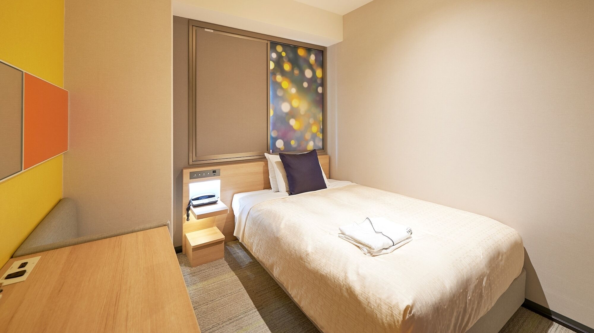 Une chambre d’hôtel avec un lit, une table de chevet et une fenêtre donnant sur un paysage agréable.
