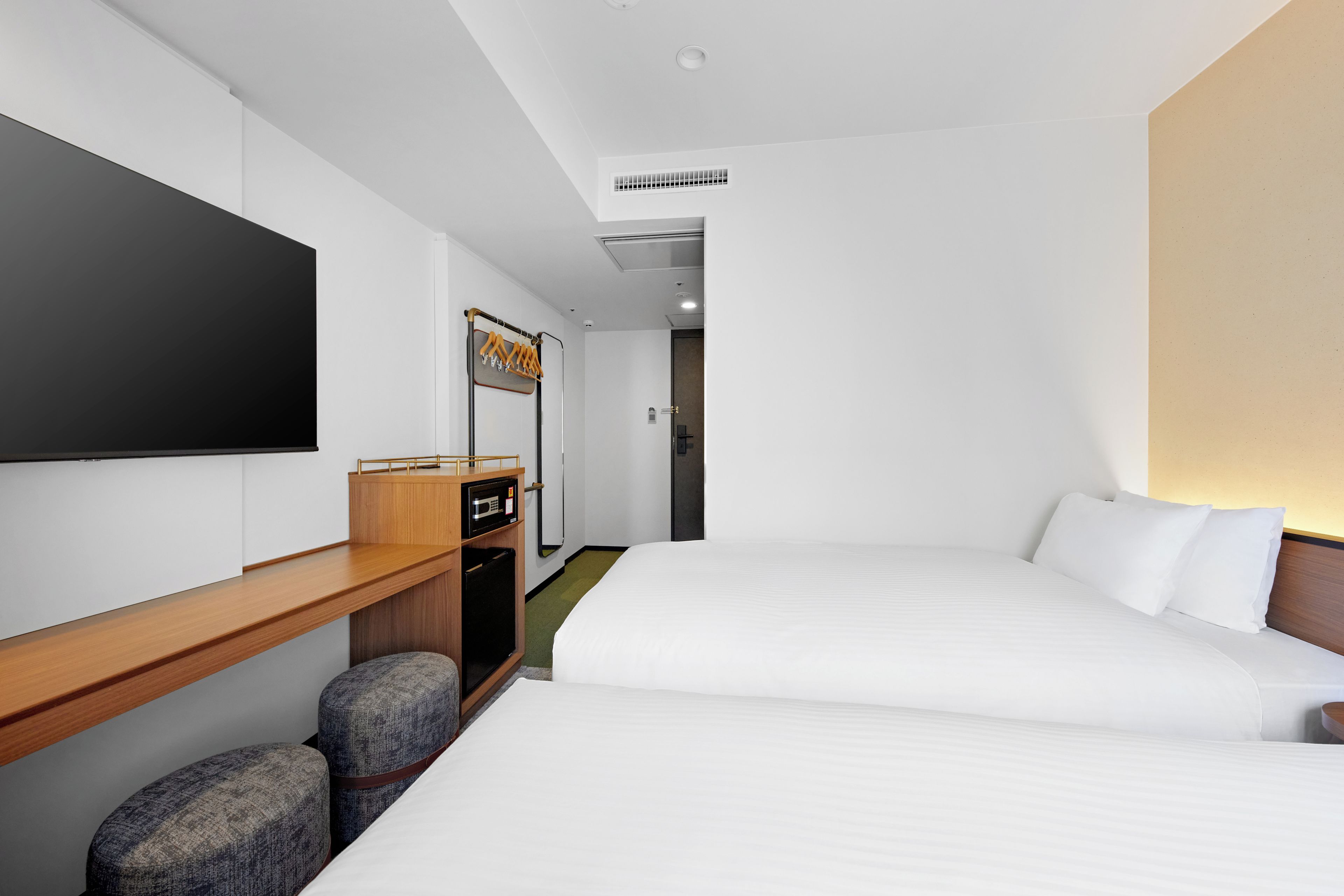 Une chambre d’hôtel équipée d’un lit, d’une télévision, d’un bureau et d’une armoire.