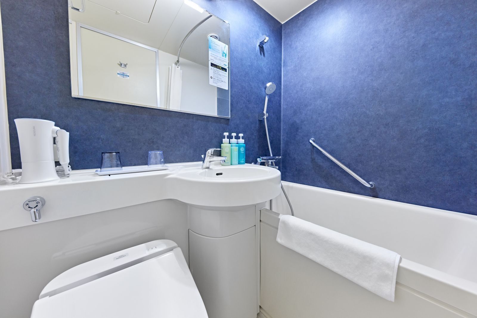 A bathroom with a white sink, mirror, and towel rack.