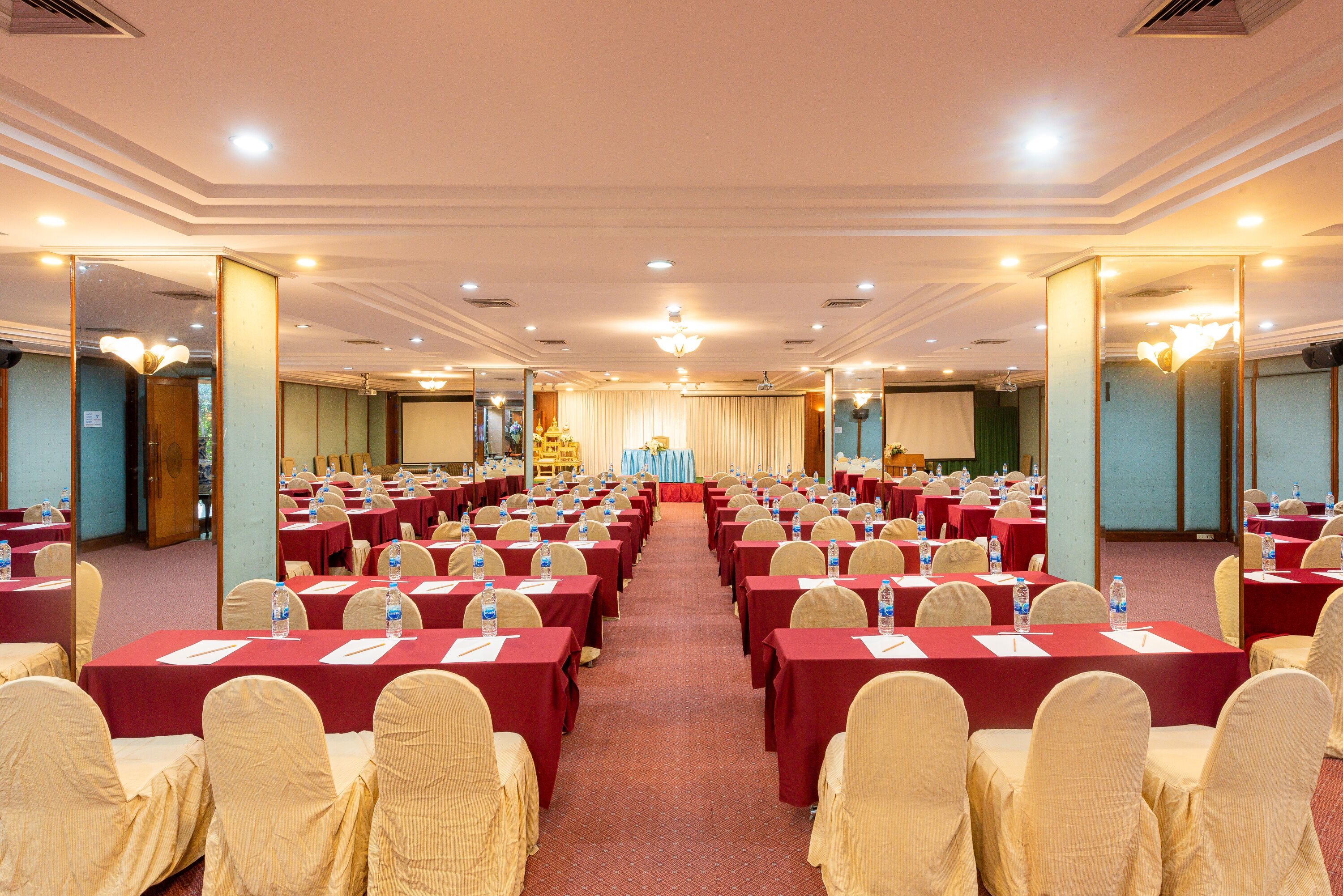 A conference room with rows of tables, chairs, and water bottles.