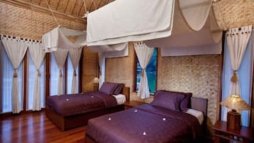 Una habitación con dos camas, techo de madera y pared de ladrillo.