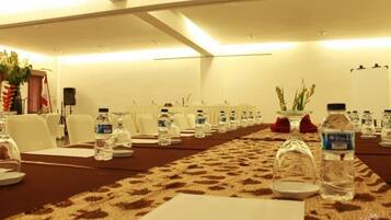 A conference room with a long table, chairs, water bottles, and a carpeted floor.