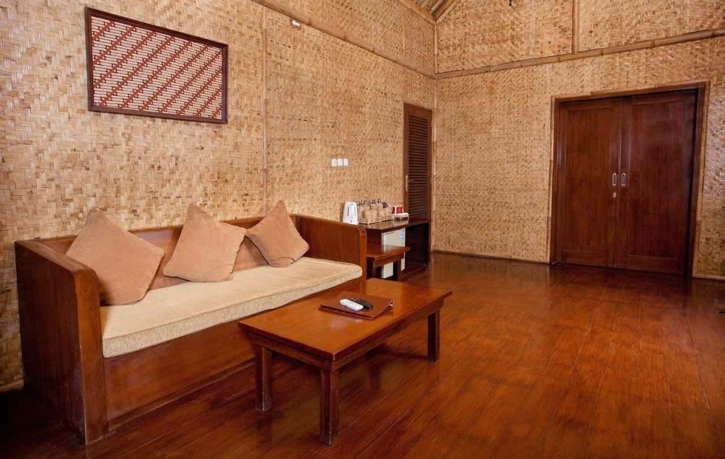 A room with a wooden sofa, a coffee table, and a wooden door.