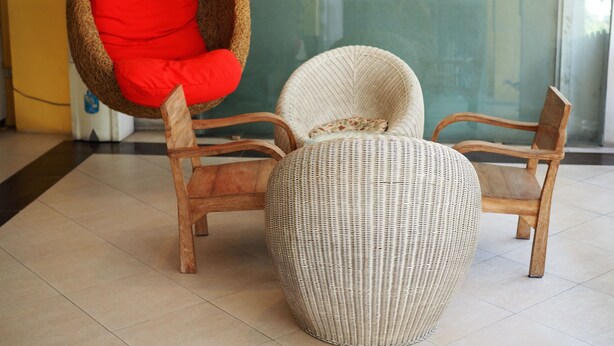 A room with two wicker chairs and a round ottoman. - The Boss's Place (Bangkok)