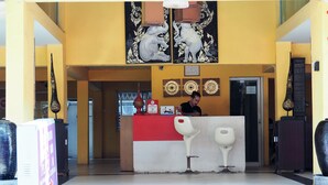 A reception desk with a red top, two white chairs, and a large decorative elephant painting above. - The Boss's Place (Bangkok)