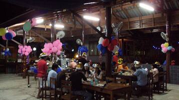 Groups gather around wooden tables in this rustic venue with high ceilings.