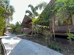 Un resort con varias villas de madera, cada una con balcón y rodeado de exuberante vegetación.