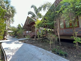 A resort with multiple wooden villas, each with a balcony and surrounded by lush greenery.