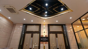 The entrance to Rachawadee Ballroom with a modern design, including a geometric ceiling and a sign above the doors. - Grand Ratchapruek Hotel (Pak Kret)