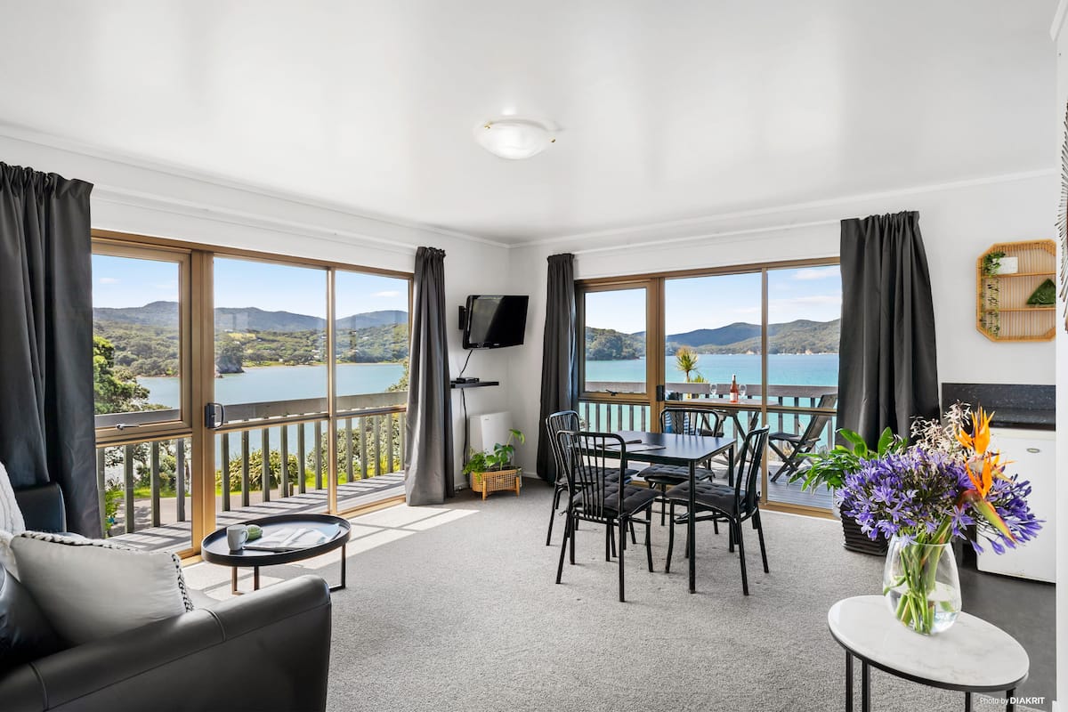 Ein modernes Zimmer mit Balkon, Essbereich und Fernseher.