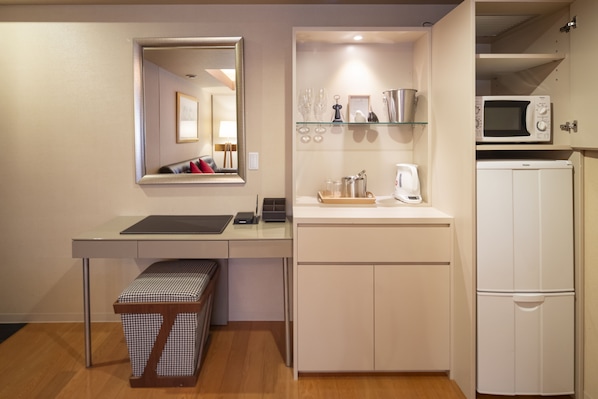 A compact kitchenette with a microwave, a coffee maker, and a small refrigerator.
